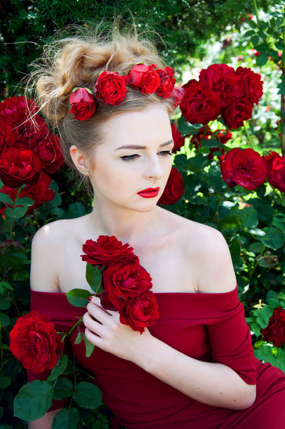 Lady vamp in crimson red dress with naked shoulders and red rose - Photo, image