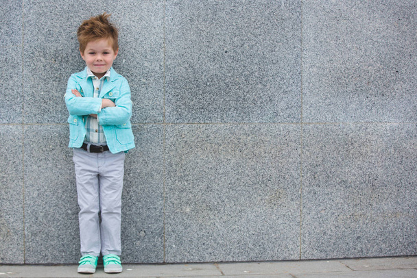 Fashion kid posing near gray wall - Foto, Imagem