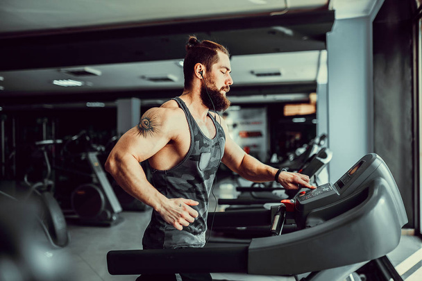 Muscle man running on treadmill. - Фото, изображение