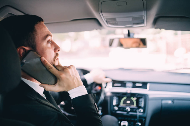 Araba sürüş sırasında telefonunu kullanarak iş adamı - Fotoğraf, Görsel