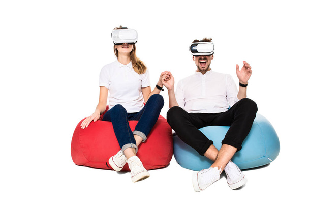 Ενθουσιασμένος ζευγάρι βιώνει την εικονική πραγματικότητα που κάθονται στο beanbags απομονώνονται σε λευκό φόντο - Φωτογραφία, εικόνα