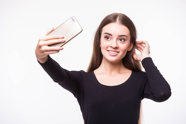 ストリート スタイルの服が白い背景で隔離の携帯電話で selfie を取っての豪華な若い女性 - 写真・画像