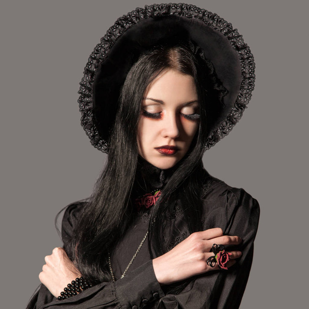 Portrait of brunette woman in black dress and classic gothic sty - 写真・画像