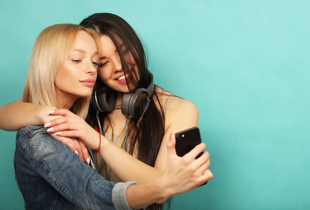 Two  girls friends in hipster outfit make selfie on a phone. - Foto, immagini