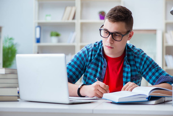 Νεαρός έφηβος προετοιμάζεται για τις εξετάσεις σε ένα γραφείο σε εσωτερικούς χώρους - Φωτογραφία, εικόνα