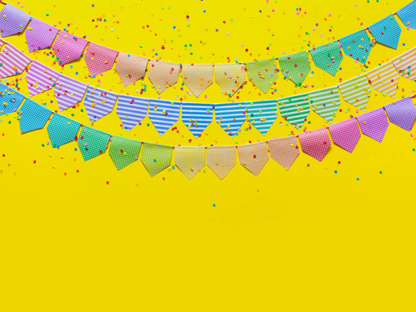 Colored flags garland. Yellow background. - Foto, Imagen