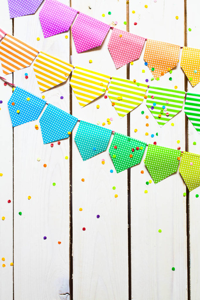 Colored flags garland. The background is white wood. - Foto, Imagem
