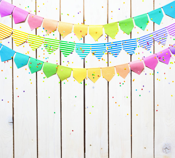 Colored flags garland. The background is white wood. - Foto, Imagen