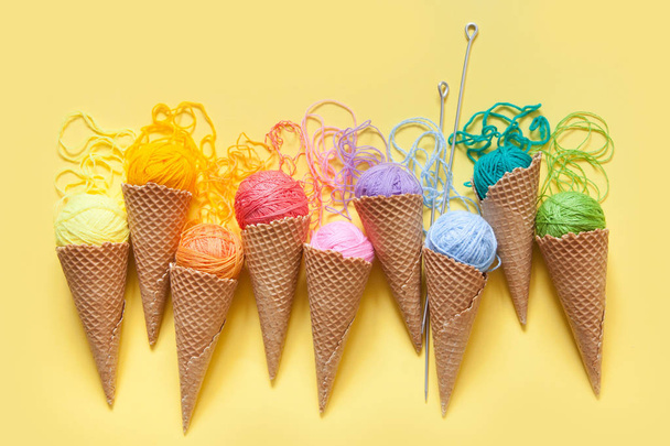Balls of yarn lie in a waffle cone for ice cream. Coloured wool. - Foto, Bild