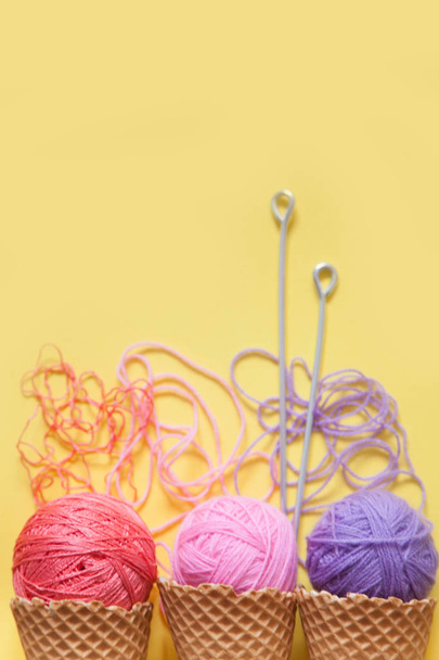 Balls of yarn lie in a waffle cone for ice cream. Coloured wool. - Fotografie, Obrázek