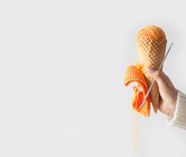 Balls of yarn lie in a waffle cone for ice cream. Coloured wool. - Foto, afbeelding