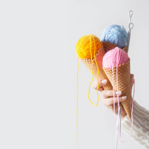 Balls of yarn lie in a waffle cone for ice cream. Coloured wool. - Foto, immagini