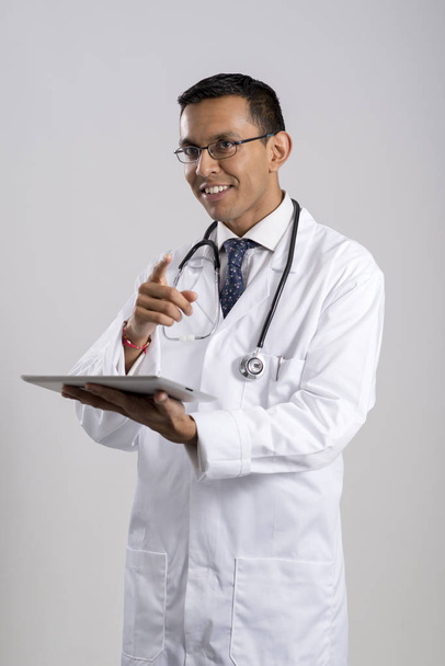 Doctor con una tableta sobre un fondo gris
 - Foto, Imagen