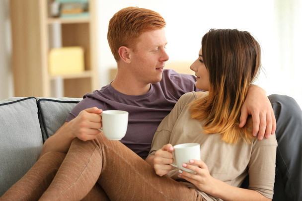 Lovely young couple resting on sofa at home - Foto, Imagem
