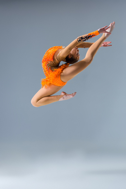 Молодая стройная гимнастка в студии
 - Фото, изображение