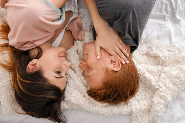 Happy young couple lying on bed - Foto, Bild