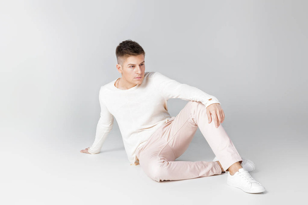 handsome young man in a white sweater - Zdjęcie, obraz