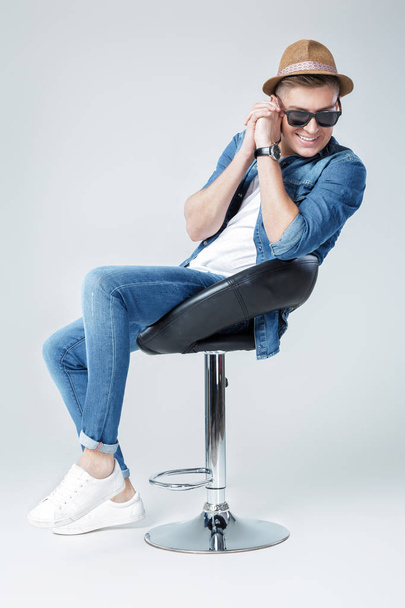 handsome man in denim sits on chair - Fotó, kép