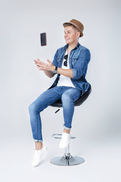 handsome man in denim sits on chair - Foto, immagini