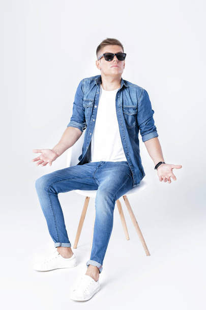 handsome man in denim sits on chair - Photo, image