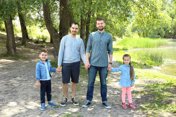 Smiling gay couple with children in park - Zdjęcie, obraz
