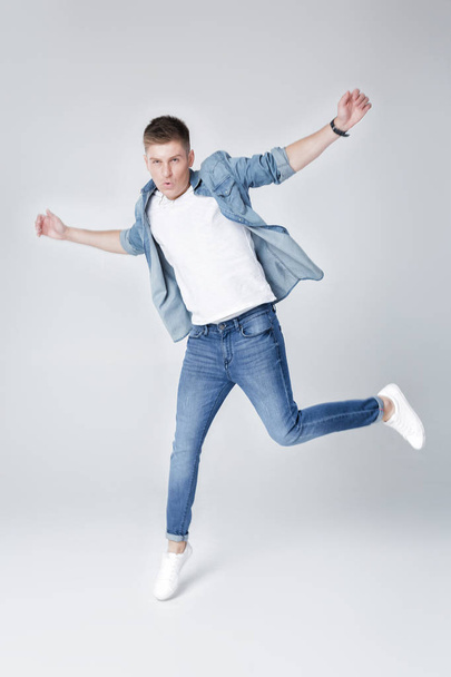 handsome man in jeans and jacket jumping - Fotó, kép