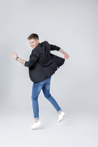 handsome man in jeans and jacket jumping - Foto, afbeelding
