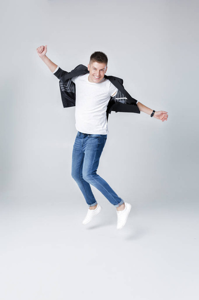 handsome man in jeans and jacket jumping - Foto, Imagem