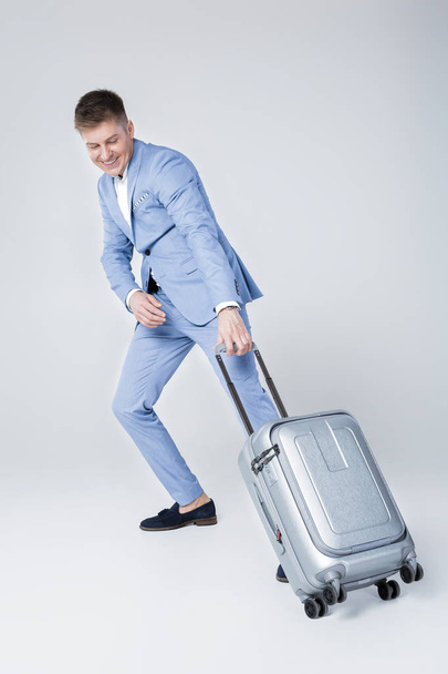 young man in blue suit  with suitcase - Fotó, kép