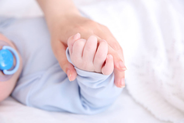 Mother holding hand of cute baby, closeup - Foto, Imagem