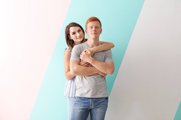 Happy young couple in love on color background - Foto, Imagen