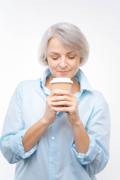 Grey-haired woman enjoying aroma of coffee - Foto, Imagem