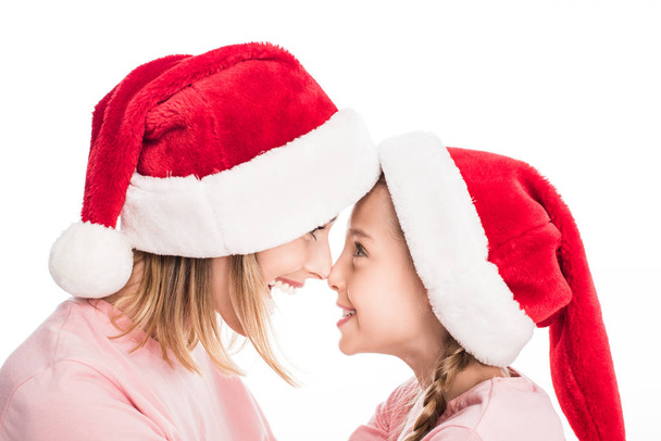 Madre e figlia in cappelli Babbo Natale - Foto, immagini