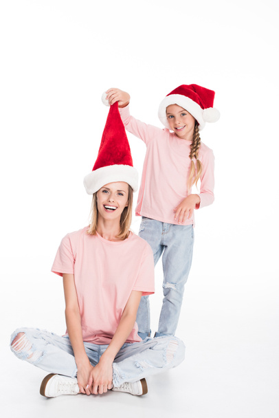 mother and daughter in santa hats - Foto, afbeelding
