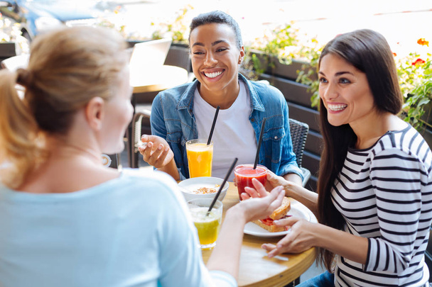 Fröhliche Frauen tratschen beim Mittagessen im Café - Foto, Bild