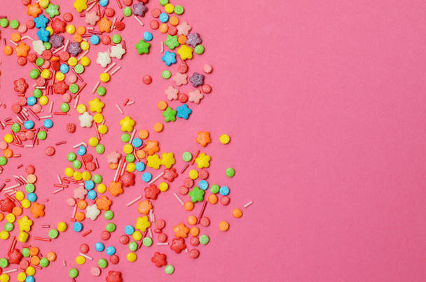 Decoração de açúcar colorido em papel rosa, vista superior layout leigos planos. Fundo da moda minimalista
. - Foto, Imagem