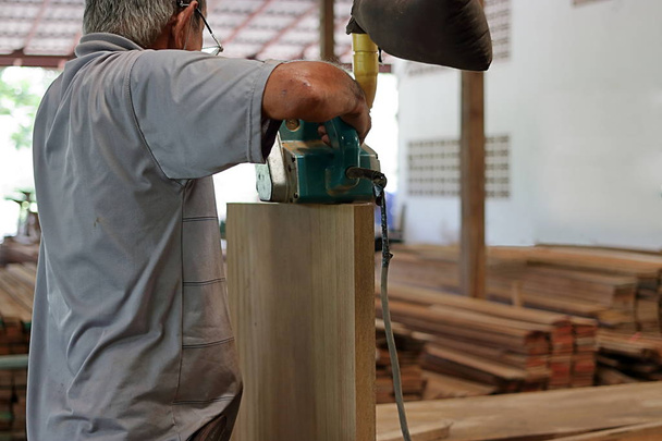 大工さんの木工ワーク ショップでベルトの研摩機を使用しての背面図 - 写真・画像