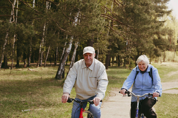 Senior paar paardrijden fietsen in de natuur - Foto, afbeelding