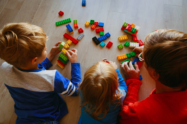 teacher and kids playing with plastic blocks - Photo, Image