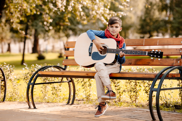 Niño con guitarra en el parque
 - Foto, imagen