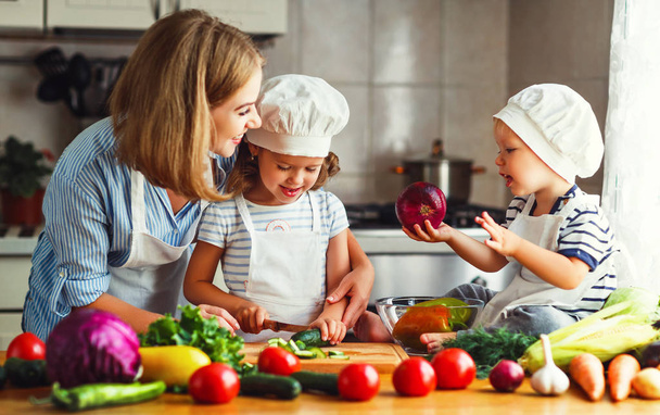Alimentação saudável. Mãe de família feliz e crianças prepara veg
 - Foto, Imagem