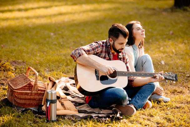 Jovem com namorada tocando guitarra
 - Foto, Imagem