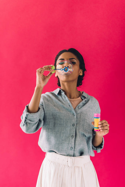 mujer afroamericana soplando burbujas de jabón
 - Foto, imagen