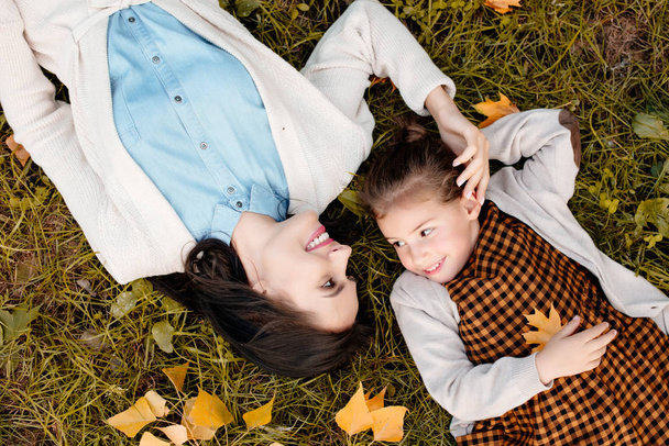 mother and daughter lying on grass - Foto, afbeelding