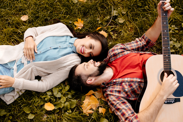 Couple lying on grass - Foto, afbeelding