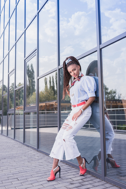  woman leaning on glass wall - 写真・画像