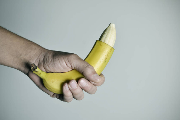 człowiek z banana z czubka jego skóry usuwane - Zdjęcie, obraz