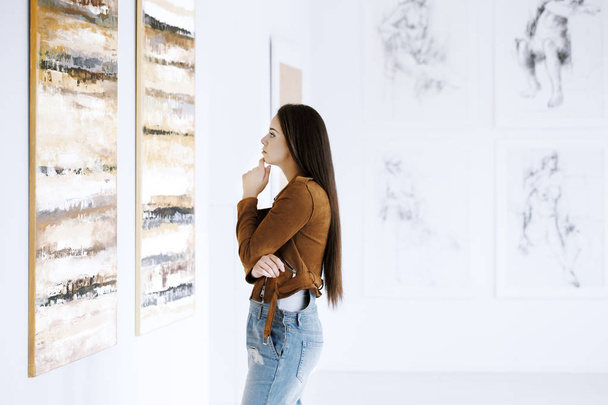 Young woman observing painting - Photo, Image