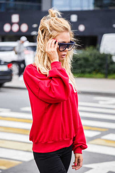 Modello in elegante occhiali da sole e camicetta rossa
 - Foto, immagini