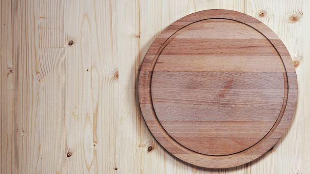 empty round wooden board for cutting on a wooden background - Fotoğraf, Görsel